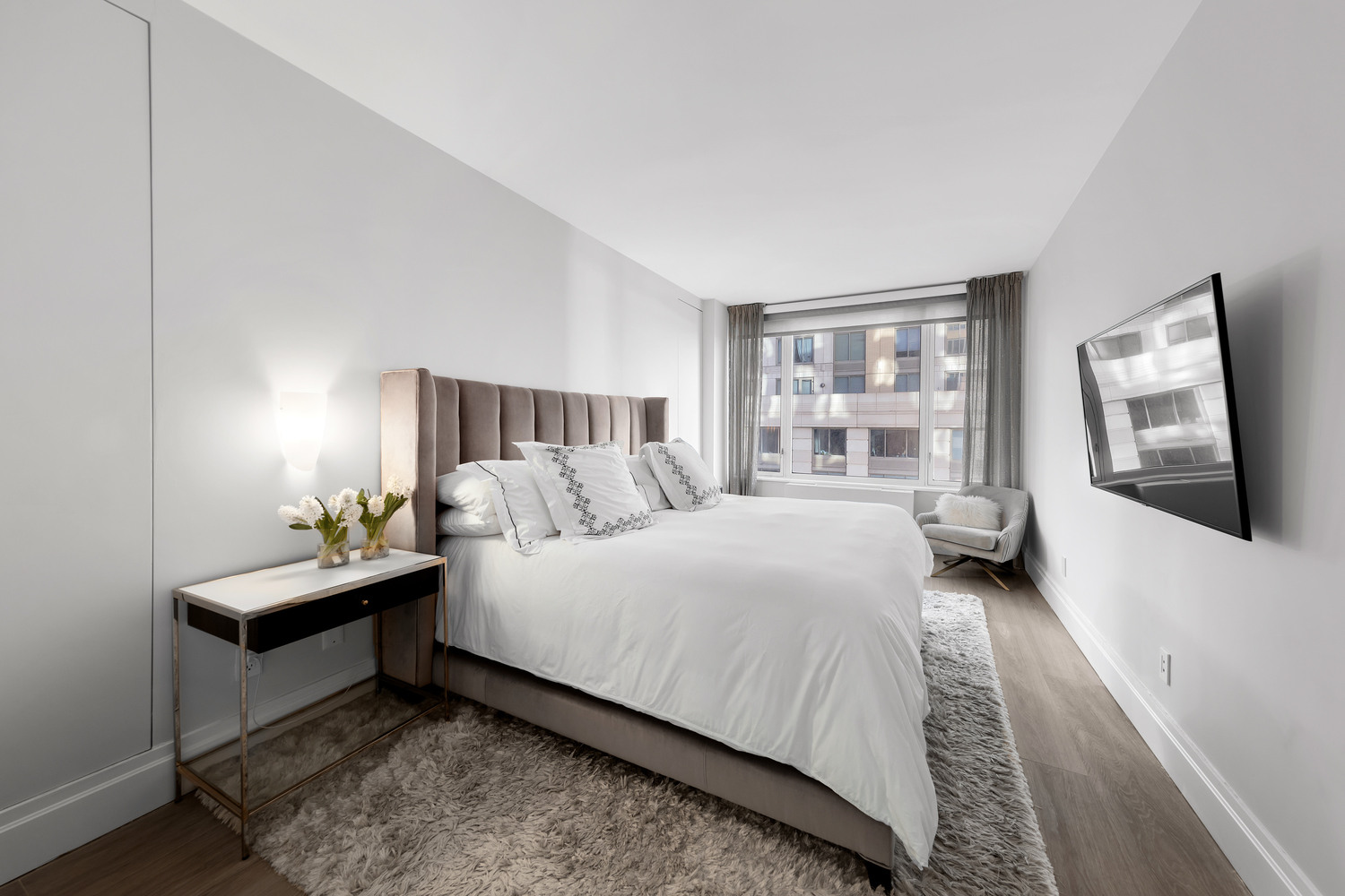 220 Riverside Boulevard, Unit 4H Manhattan, NY 10069 - Photo 8 of 15 a bedroom with a bed and a large window