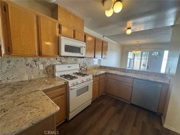 a kitchen with granite countertop a sink cabinets and stainless steel appliances