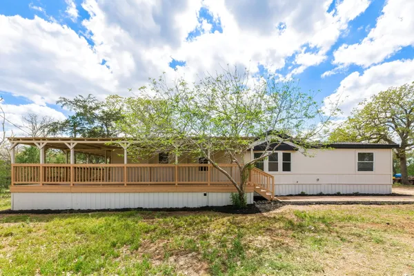 a view of a house with backyard and sitting area