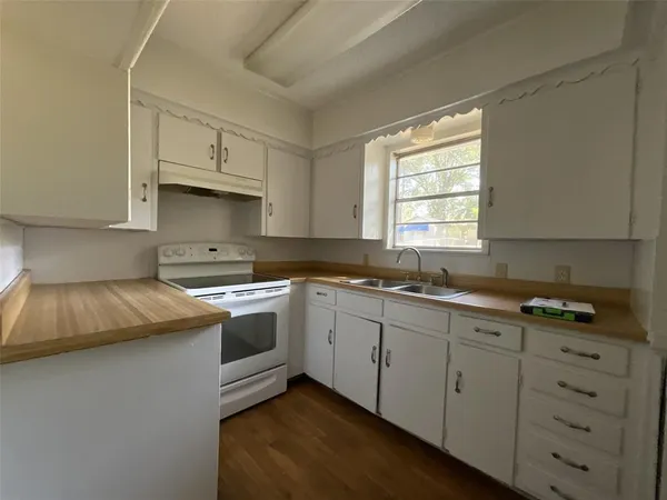 a kitchen with cabinets appliances a sink and a window
