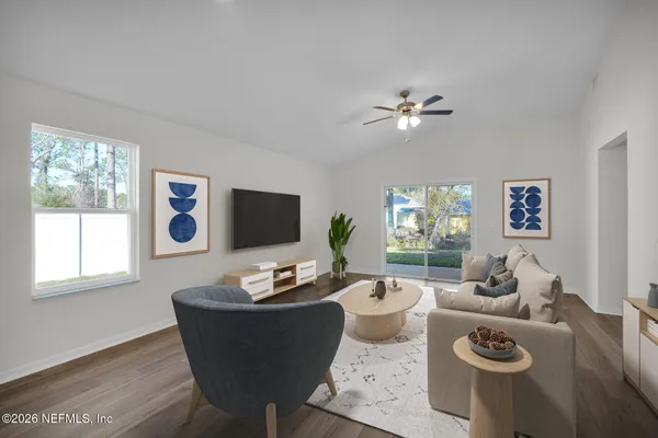 a living room with furniture a flat screen tv and a window