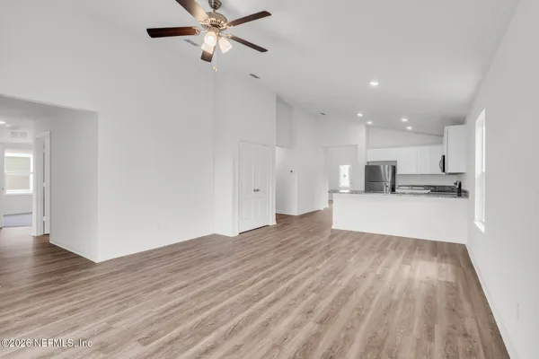 a view of kitchen with wooden floor and electronic appliances