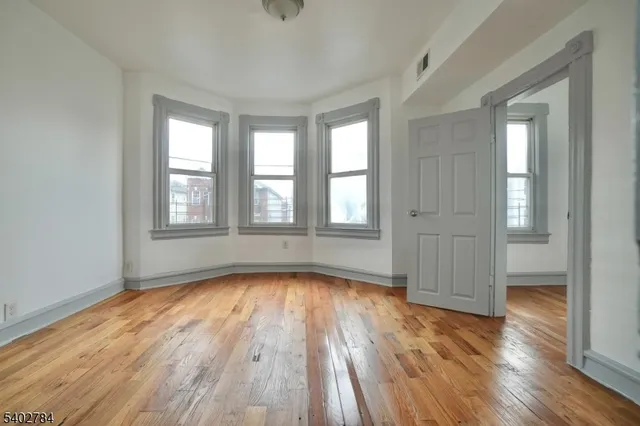 a view of a livingroom with wooden floor and windows