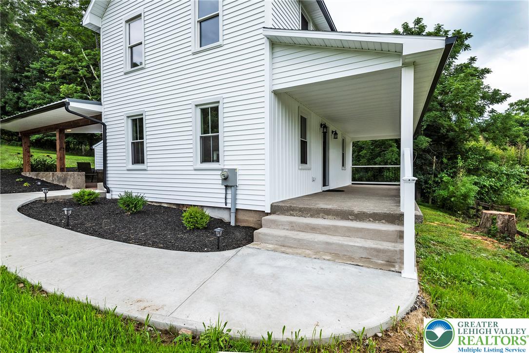 72 Allegheny Road Mount Bethel, PA 18343 - Photo 46 of 72 A classic white-sided home with a welcoming front porch and concrete steps, nestled against a verdant hillside.