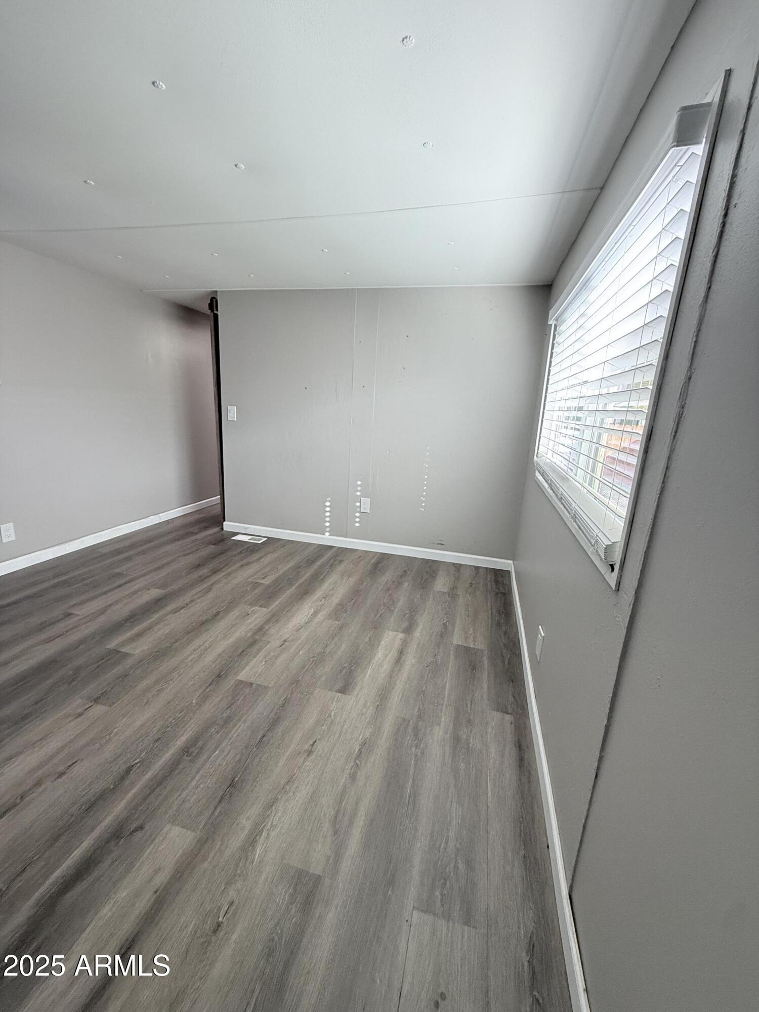 960 Peace Lane, Unit 77 Prescott, AZ 86305 - Photo 4 of 27 an empty room with wooden floor and windows