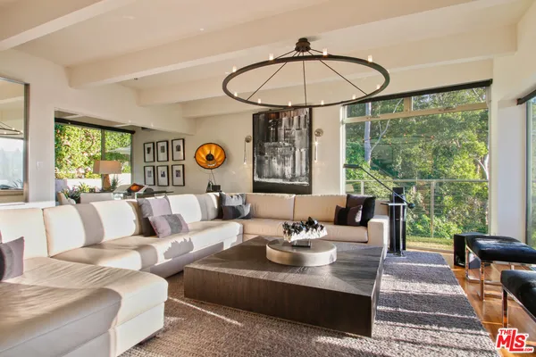 a living room with furniture and floor to ceiling windows