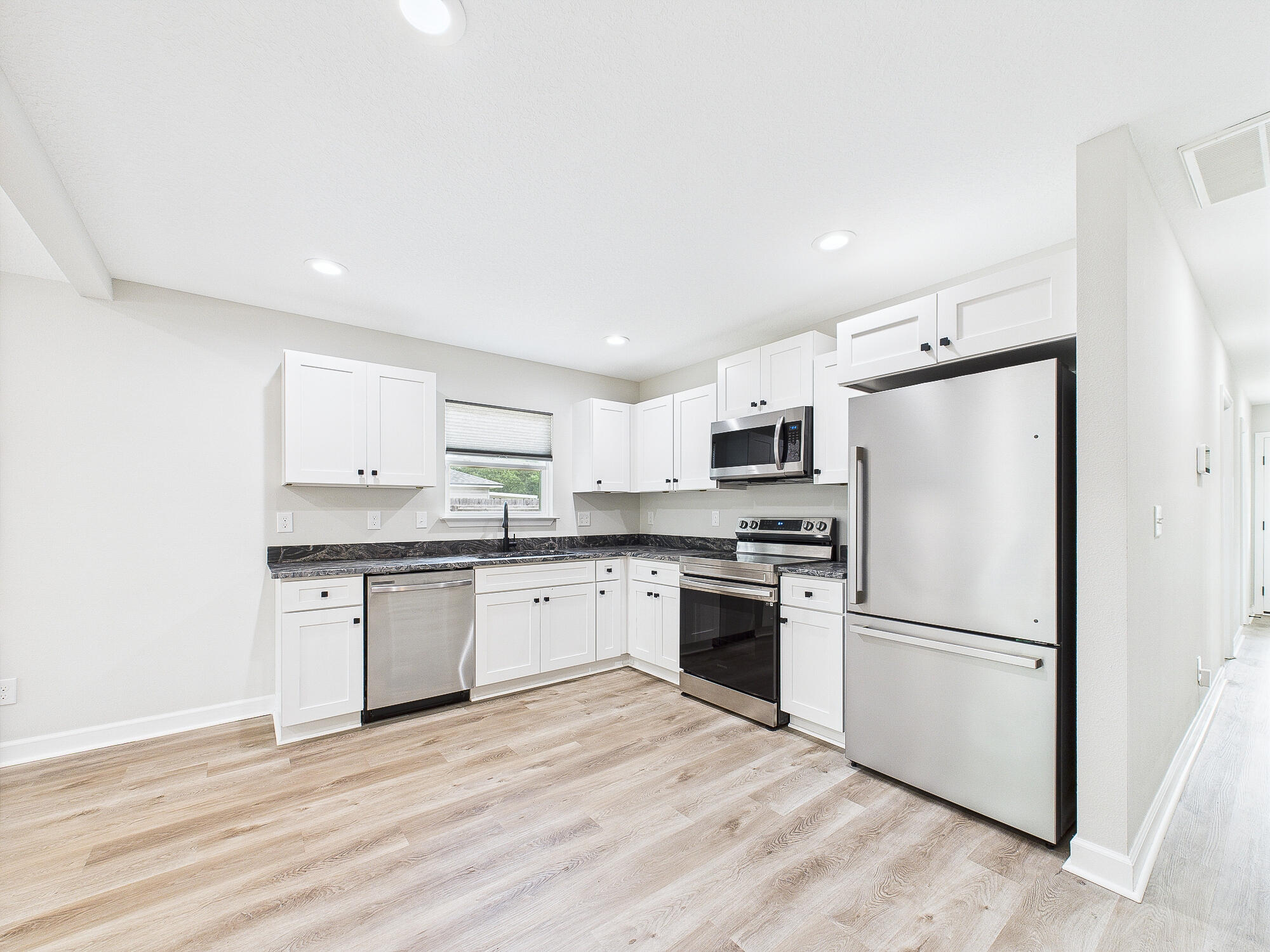 5117 Colt Drive Crestview, FL 32539 - Photo 12 of 32 a kitchen with granite countertop stainless steel appliances a refrigerator sink and microwave