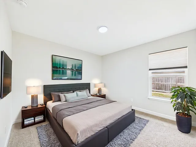 a bedroom with a bed and a potted plant