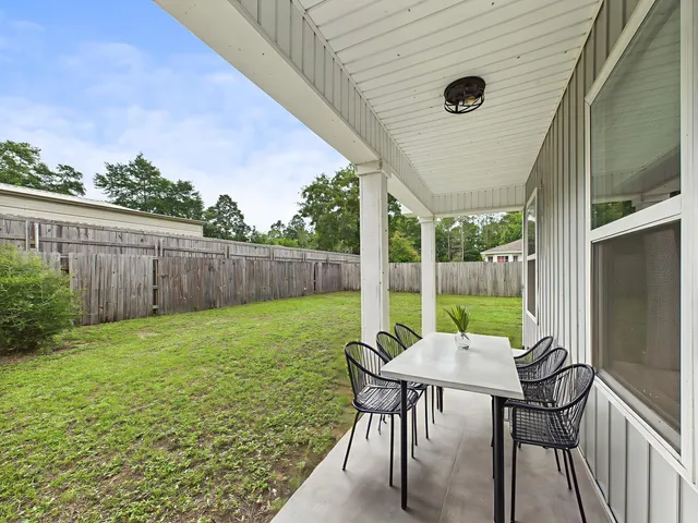 a view of a backyard with table and chairs and wooden fence