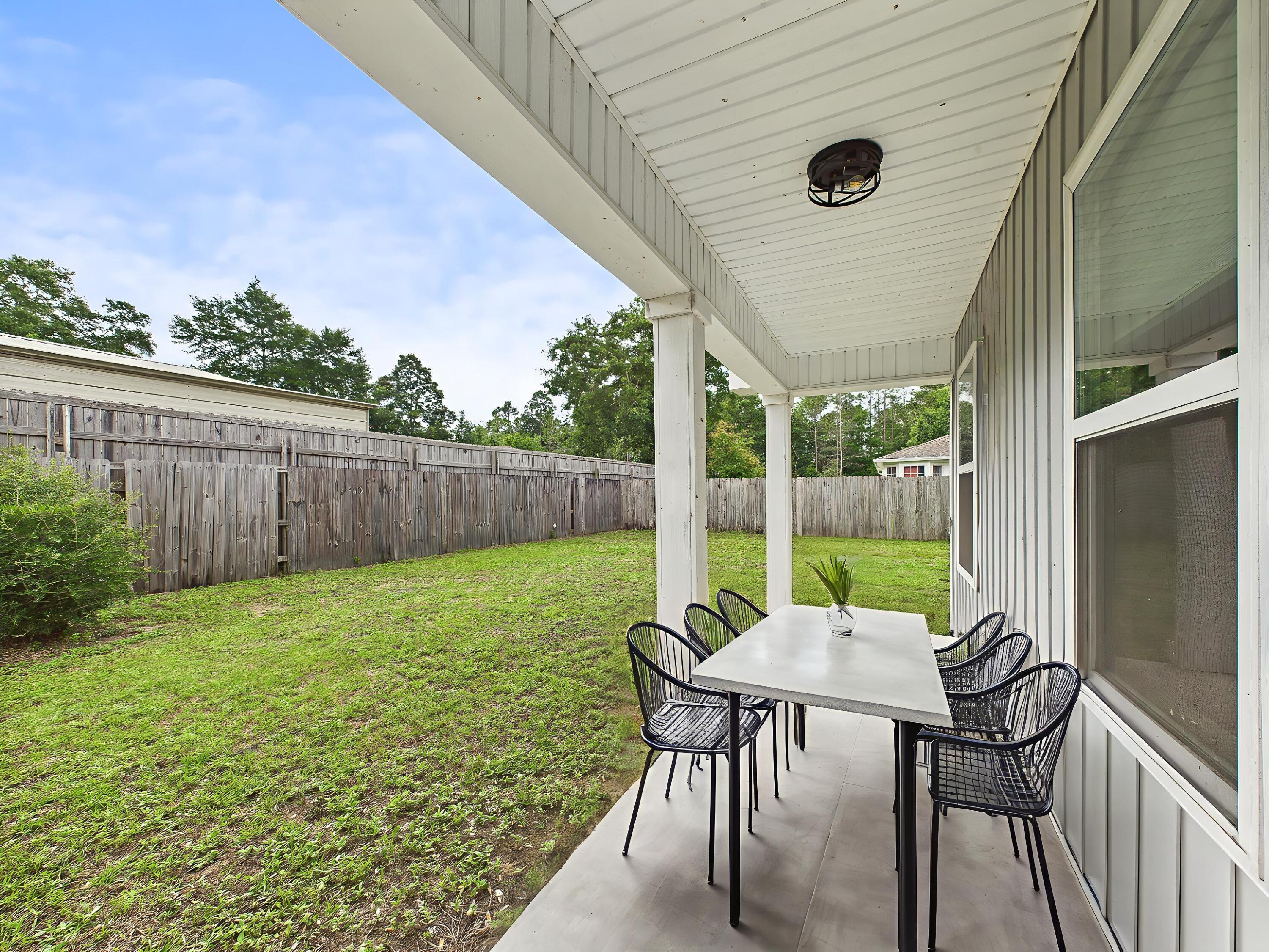 5117 Colt Drive Crestview, FL 32539 - Photo 7 of 32 a view of a backyard with table and chairs and wooden fence