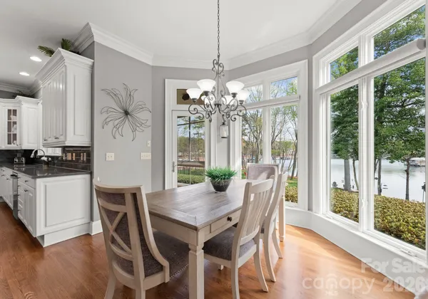 a dining room with furniture large windows and wooden floor