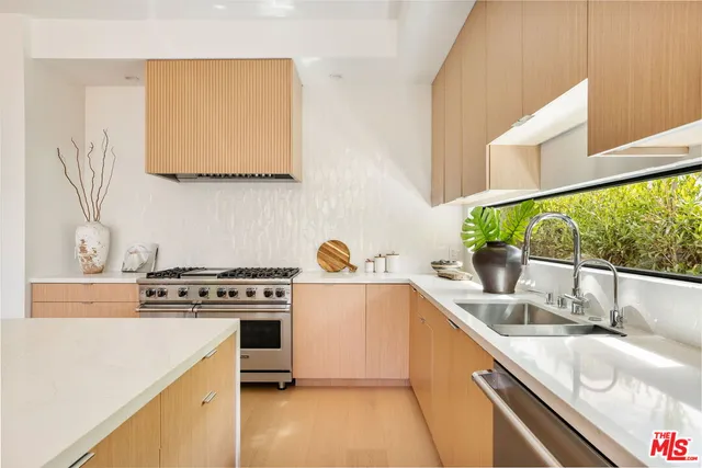 a kitchen with a sink a stove and cabinets