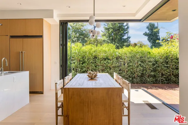 a kitchen with stainless steel appliances a stove a sink dishwasher and white cabinets with wooden floor