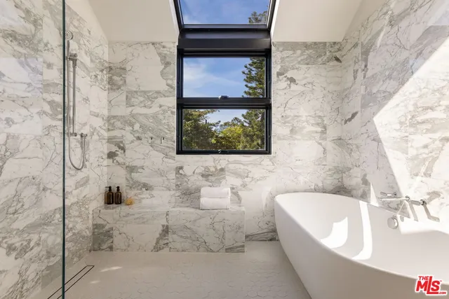 a living room with a floor to ceiling window and wooden floor