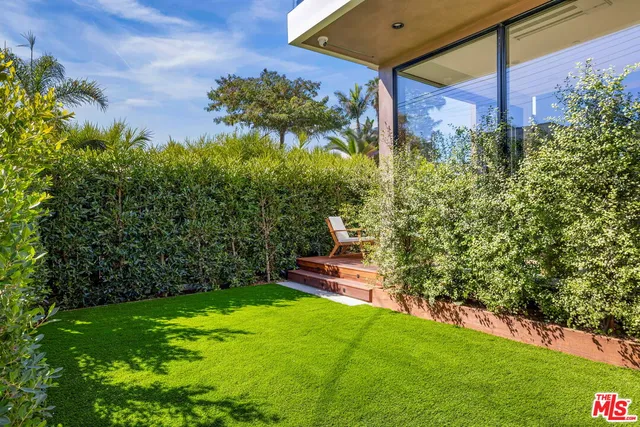 a view of a dining room with furniture a potted plant and a chandelier