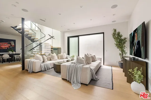 a living room with furniture a rug and a large window