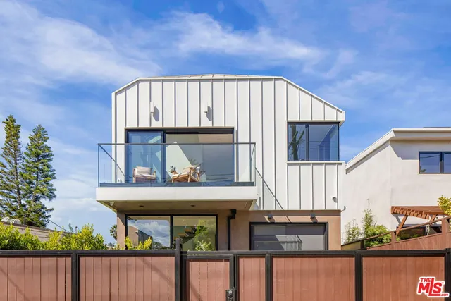 a view of a patio with table and chairs potted plants and floor to ceiling window and potted plants
