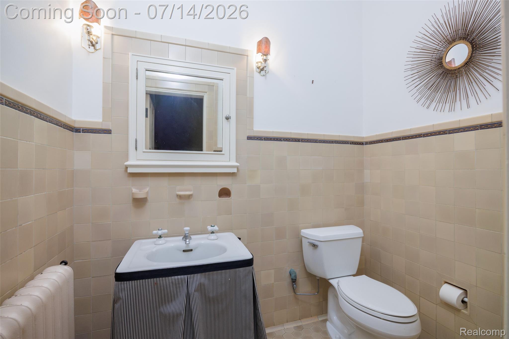 189 Cloverly Road Grosse Pointe, MI 48236 - Photo 34 of 96 Bathroom featuring neutral tile walls with a decorative trim, a pedestal sink, a wall-mounted medicine cabinet with a mirror, and a white toilet