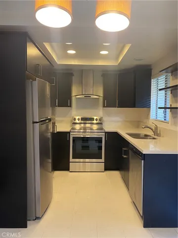 a kitchen with stainless steel appliances granite countertop a stove a sink and a refrigerator