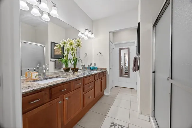a bathroom with a granite countertop sink a mirror and a shower