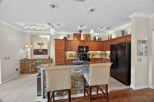 a kitchen with stainless steel appliances granite countertop a table chairs stove and refrigerator