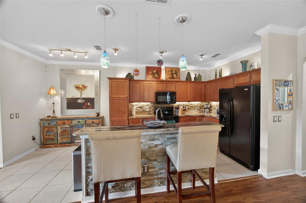 9106 Southwest 65th Loop Ocala, FL 34481 - Photo 7 of 38 a kitchen with stainless steel appliances granite countertop a table chairs stove and refrigerator