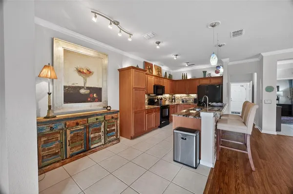 a kitchen with stainless steel appliances kitchen island granite countertop a refrigerator a stove top oven and white cabinets