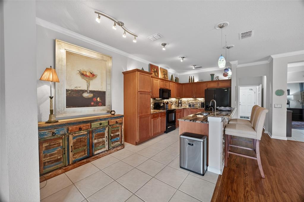 9106 Southwest 65th Loop Ocala, FL 34481 - Photo 8 of 38 a kitchen with stainless steel appliances kitchen island granite countertop a refrigerator a stove top oven and white cabinets