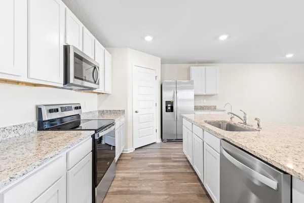 a kitchen with stainless steel appliances granite countertop a sink stove and refrigerator