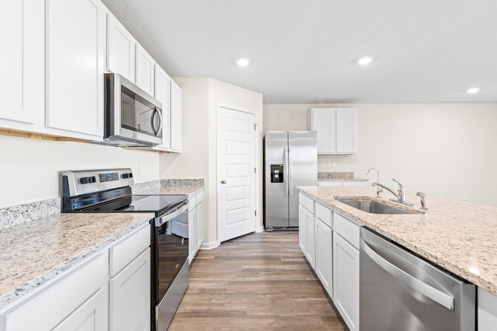 733 Quintana Street Crestview, FL 32539 - Photo 13 of 25 a kitchen with stainless steel appliances granite countertop a sink stove and refrigerator
