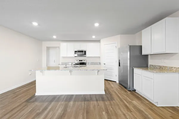 a view of kitchen with stainless steel appliances refrigerator stove microwave and cabinets