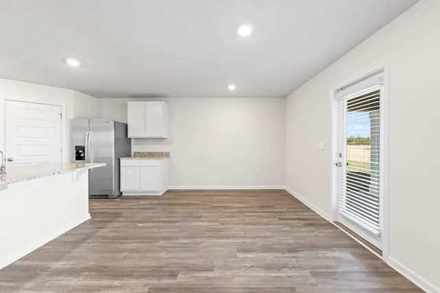 a view of a kitchen with wooden floor and electronic appliances