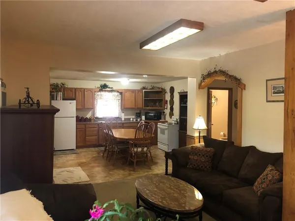 a living room with furniture a fireplace and a kitchen view