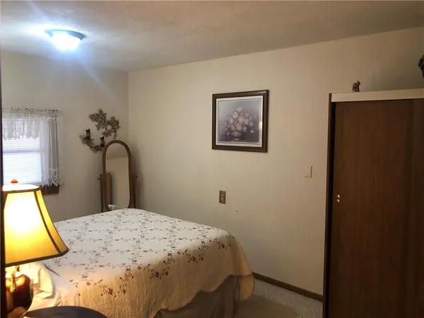 a bedroom with a bed and a dresser with mirror