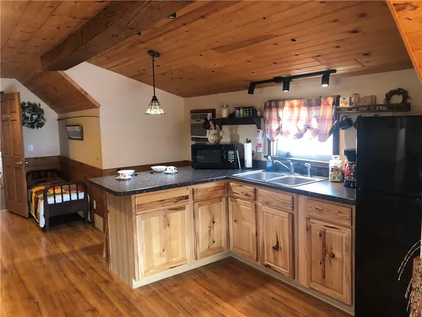 a kitchen with granite countertop a sink cabinets and wooden floor