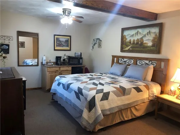 a kitchen with a table chairs and a painting on the wall