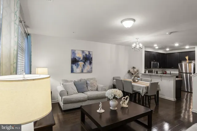 a living room with furniture and a dining table with rug