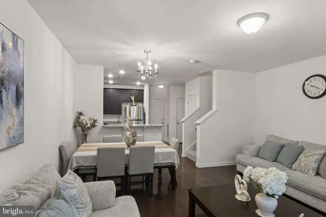a living room with furniture a dining table and a chandelier