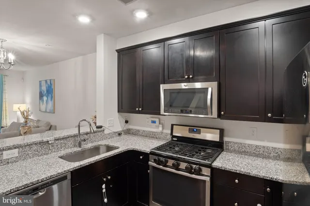 a kitchen with granite countertop cabinets stainless steel appliances and sink