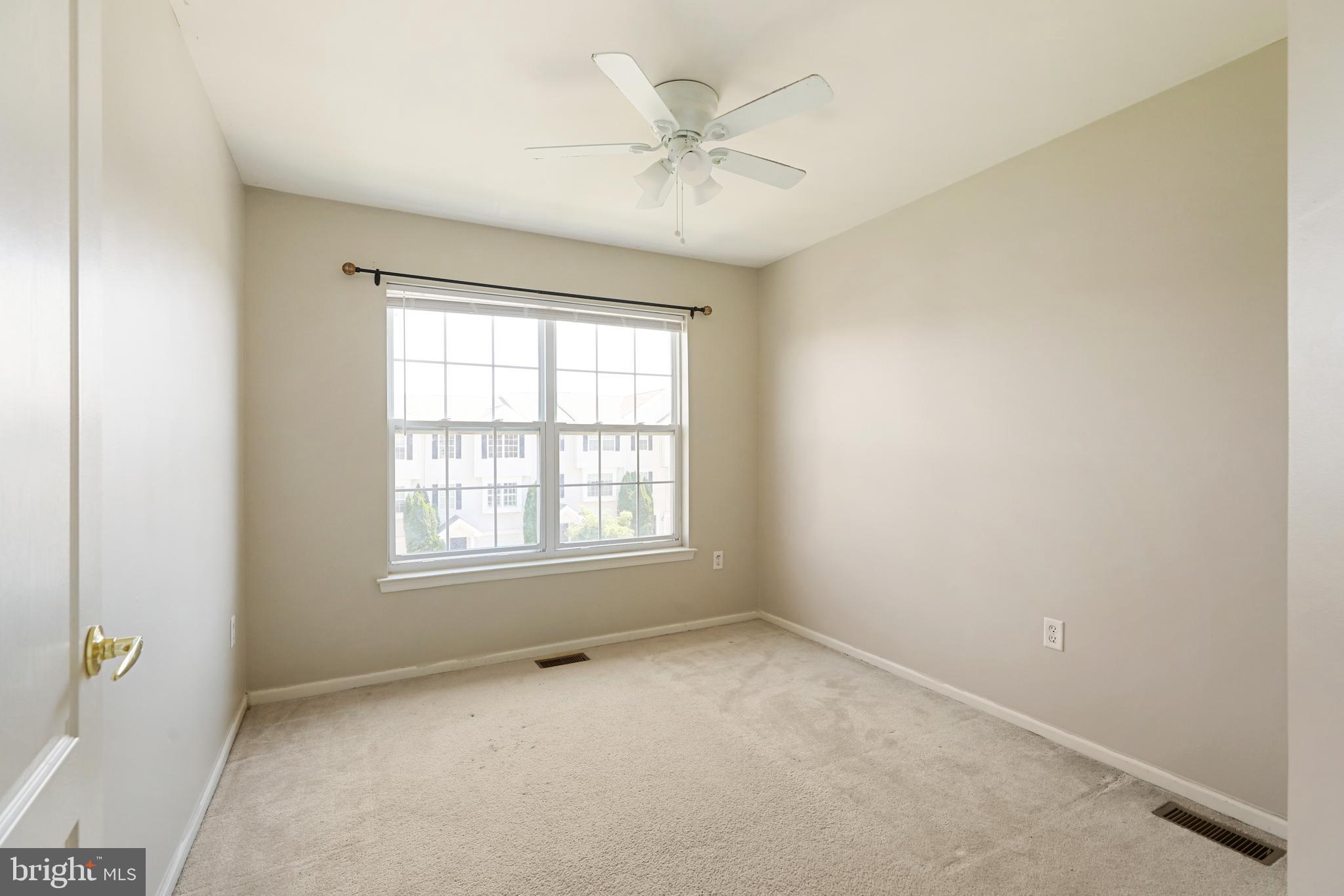 1041 Buckingham Thorofare, NJ 08086 - Photo 31 of 35 an empty room with a ceiling fan and windows