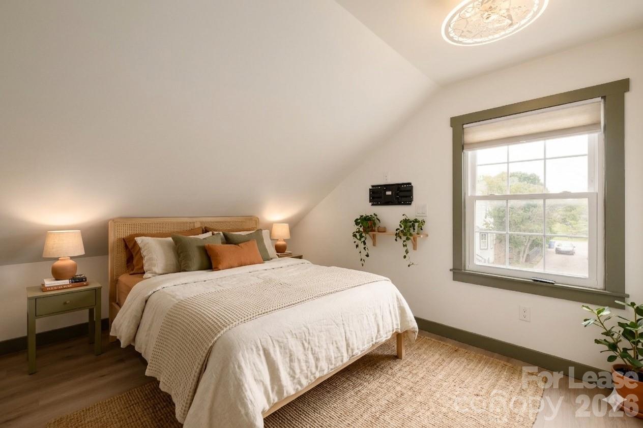 8478 Rocky River Road, Unit HOUSE B Harrisburg, NC 28075 - Photo 5 of 7 a bed sitting in a bedroom next to a window