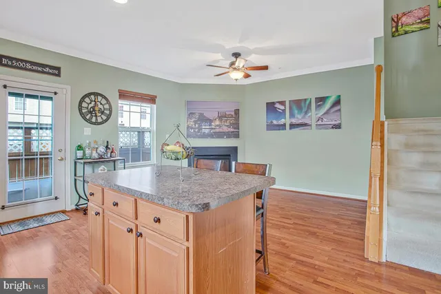 a view of hallway with window and wooden floor