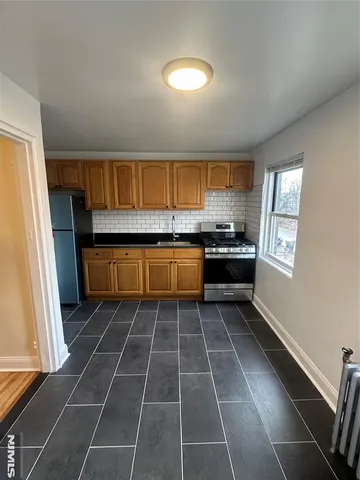 a kitchen with stainless steel appliances a stove a sink and a refrigerator