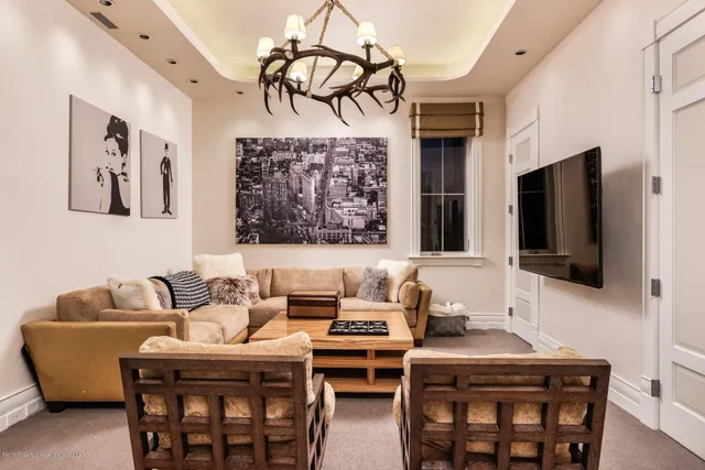 a living room with furniture a flat screen tv and kitchen view