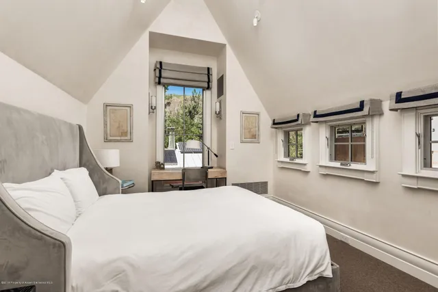 a bedroom with a bed and a large window