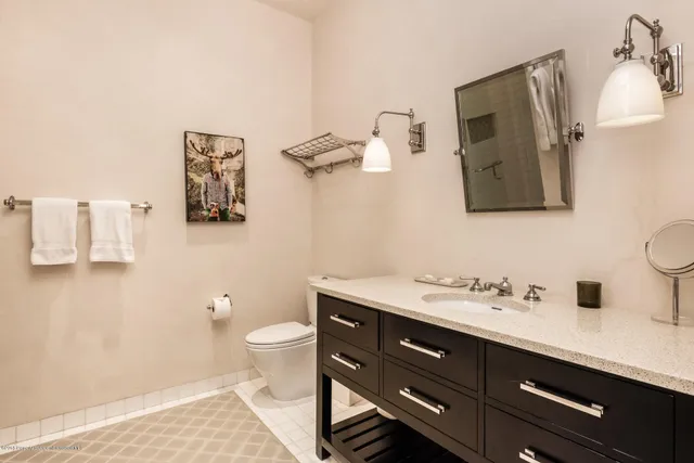 a bathroom with a sink a toilet and mirror
