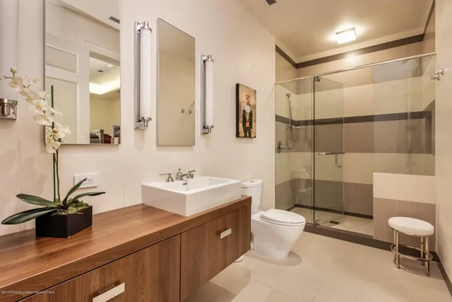 a bathroom with a sink a toilet and shower