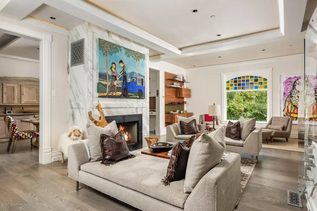 a living room with furniture fireplace and a large window