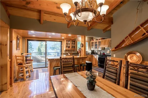 a view of a dining room with furniture a chandelier and wooden floor