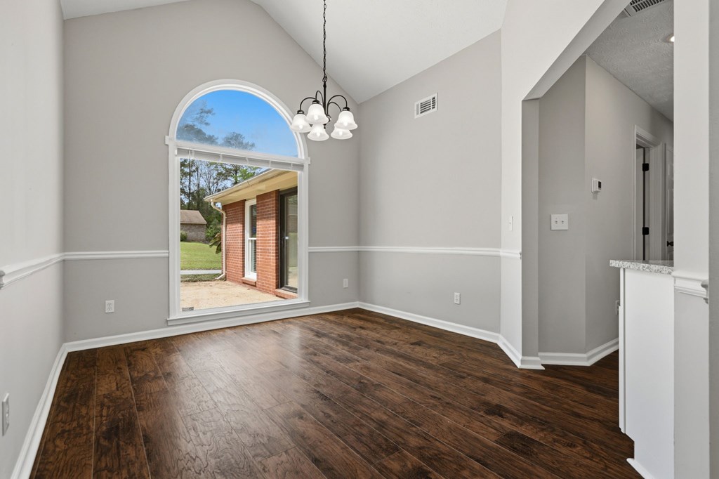 2222 Barnes Drive Columbus, GA 31907 - Photo 25 of 49 an empty room with wooden floor chandelier and windows